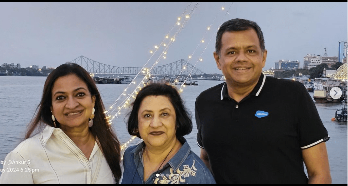 Photo of Sangeeta Giri Gundala next to a woman an a man, posing in front of a bridge.